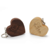 Two heart-shaped solid wood USB drives in walnut and maple wood with metal key rings, customizable engraved text on surface