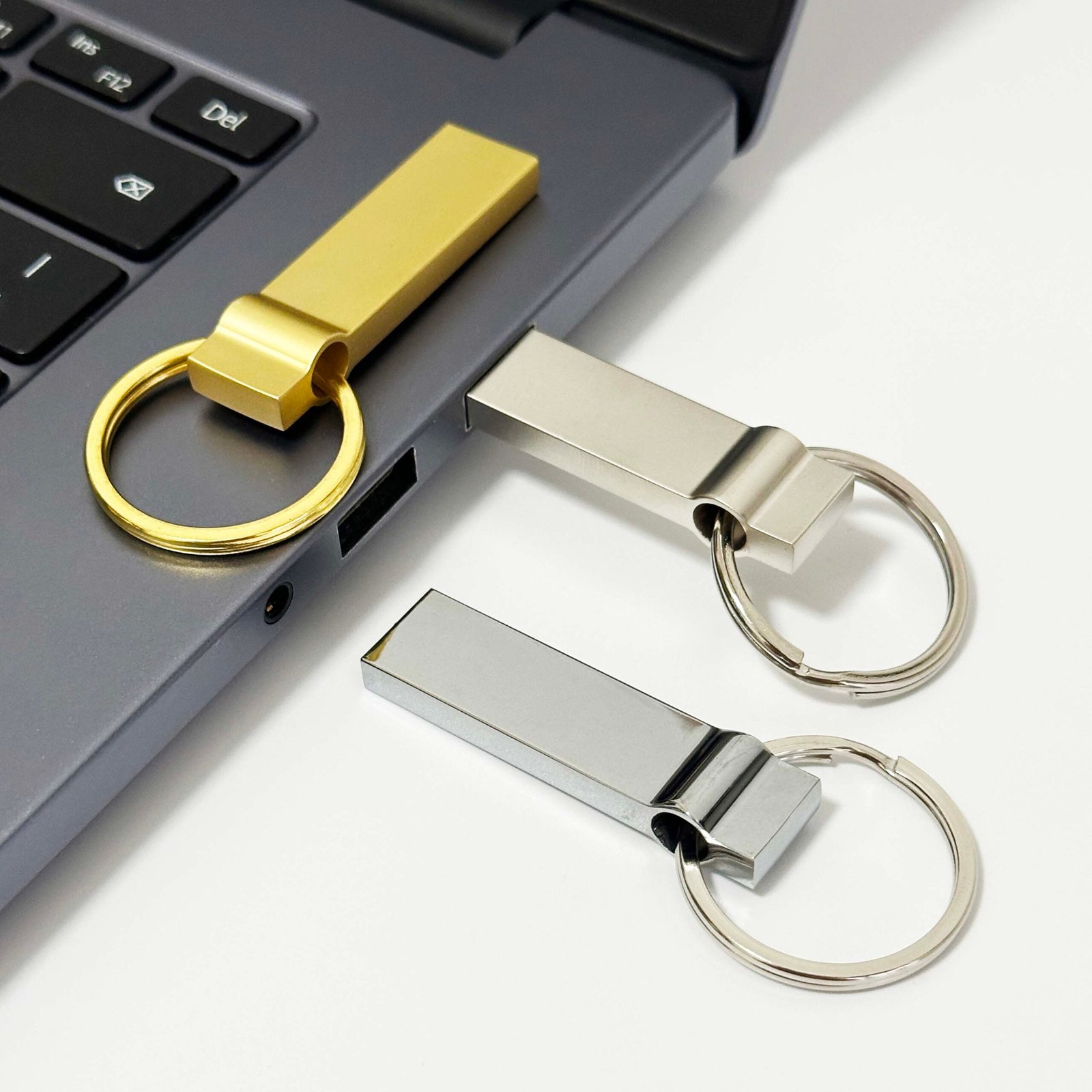 Metal keyring USB flash drive plugged into laptop USB port