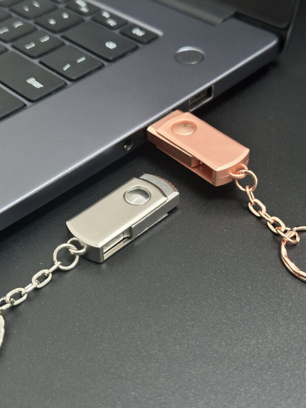 Metal swivel pendrive plugged into laptop USB port, swivel cap rotated open